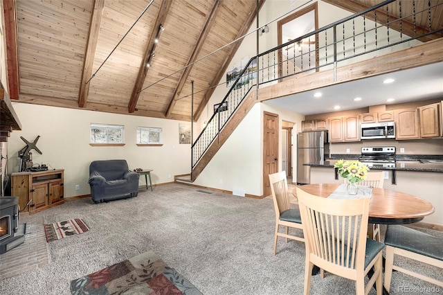 12569 S Parker Ave, Pine, CO 80470 - dining space with light carpet, a wood stove, baseboards, wood ceiling, and stairway