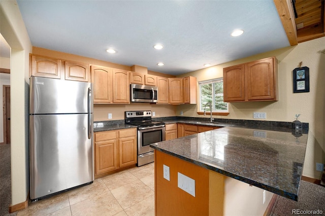 12569 S Parker Ave, Pine, CO 80470 - kitchen with stainless steel appliances, dark stone countertops, recessed lighting, and a peninsula