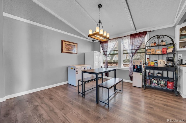 dining space featuring a textured ceiling, a chandelier, lofted ceiling, and dark hardwood / wood-style floors