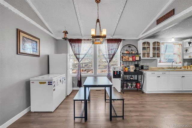 kitchen with decorative light fixtures, refrigerator, a notable chandelier, a textured ceiling, and white cabinets