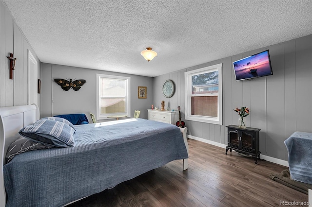 bedroom featuring a wood stove and dark hardwood / wood-style floors