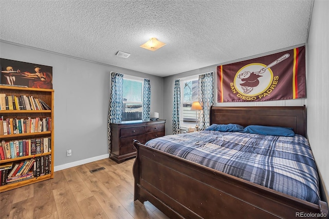 bedroom featuring light hardwood / wood-style floors and a textured ceiling