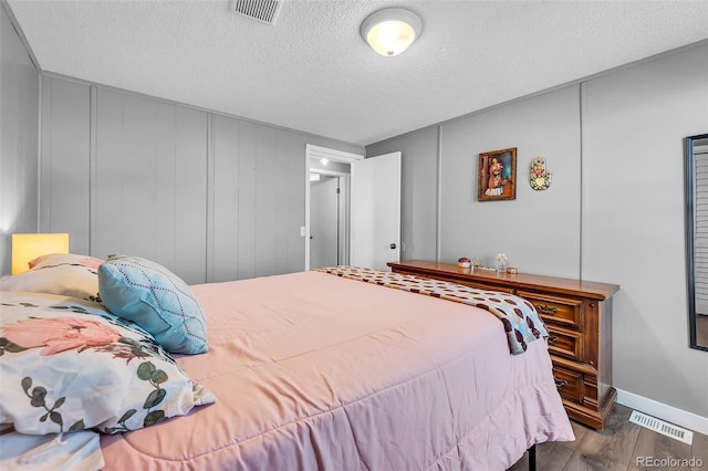 bedroom featuring a textured ceiling and hardwood / wood-style floors