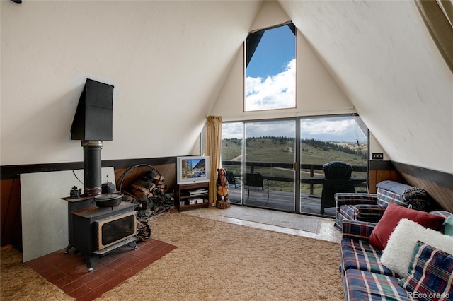 63 Welsh Cob Ln, Jefferson, CO 80456 - living area featuring wainscoting, vaulted ceiling, wooden walls, and a wood stove