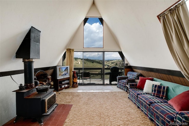 63 Welsh Cob Ln, Jefferson, CO 80456 - living area featuring a wood stove, a wainscoted wall, carpet flooring, and high vaulted ceiling
