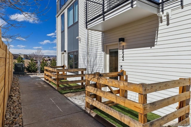 view of exterior entry with a patio and fence