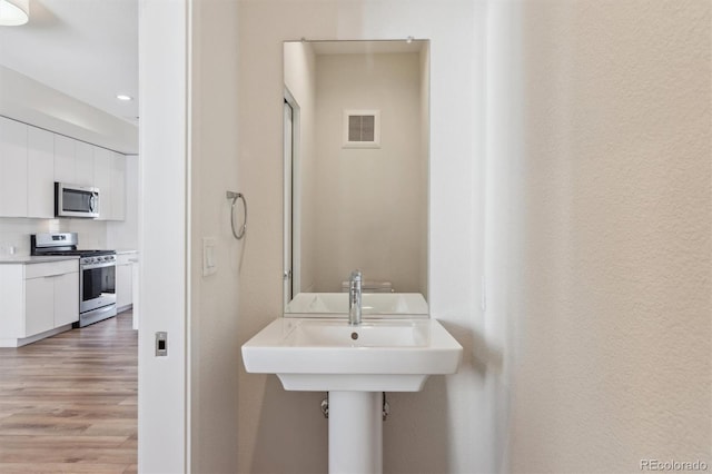 bathroom featuring wood finished floors and visible vents