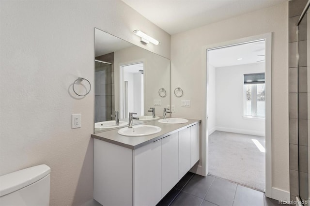 full bath featuring double vanity, an enclosed shower, a sink, and toilet