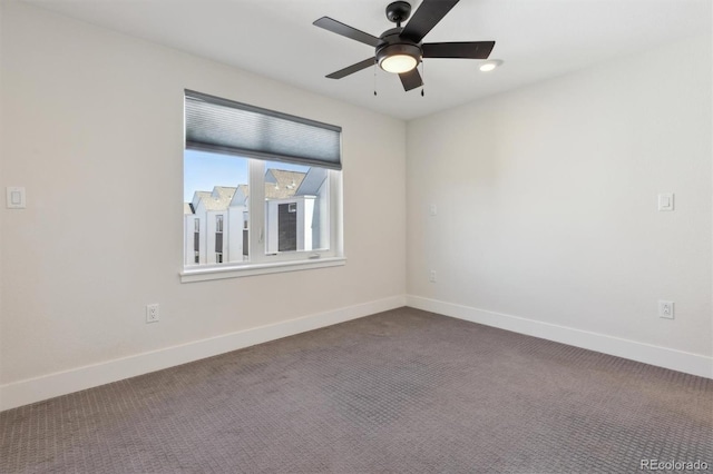 empty room with ceiling fan, baseboards, and dark colored carpet