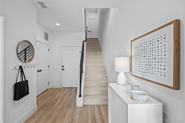 foyer entrance with light wood-style floors, recessed lighting, stairway, and visible vents