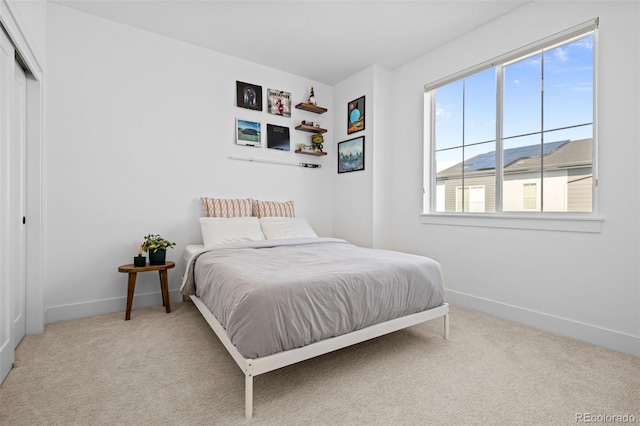 carpeted bedroom with a closet and baseboards