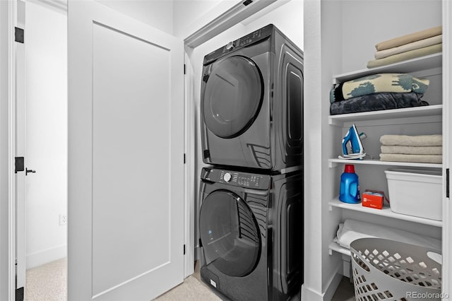 clothes washing area featuring laundry area and stacked washer and clothes dryer
