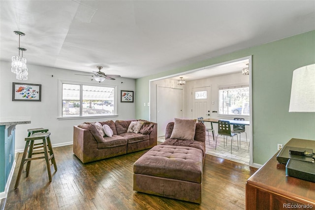 living room featuring ceiling fan with notable chandelier and dark hardwood / wood-style floors