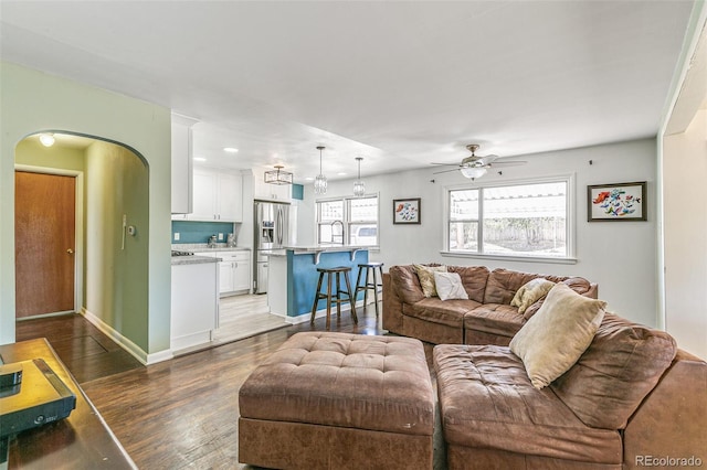 living room with ceiling fan and dark wood-type flooring