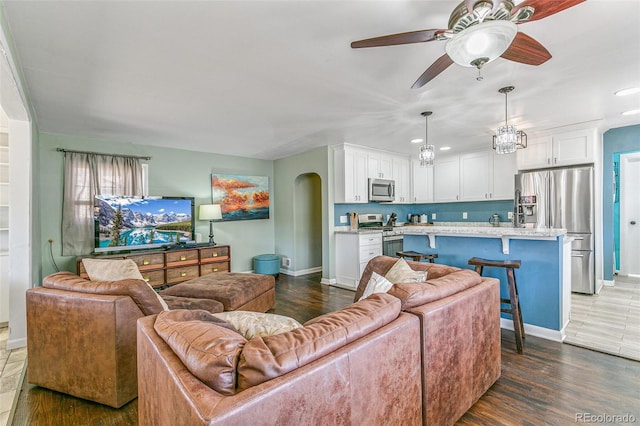 living room with dark wood-type flooring and ceiling fan