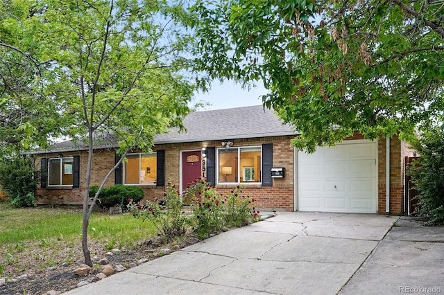 981 Ursula St, Aurora, CO 80011 - ranch-style home featuring brick siding, a garage, driveway, and roof with shingles