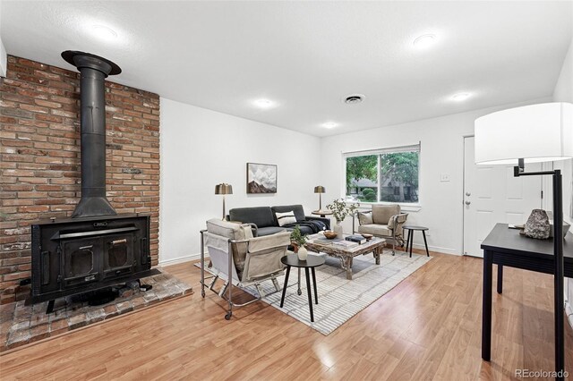 981 Ursula St, Aurora, CO 80011 - living area with a wood stove, light wood-style floors, and baseboards