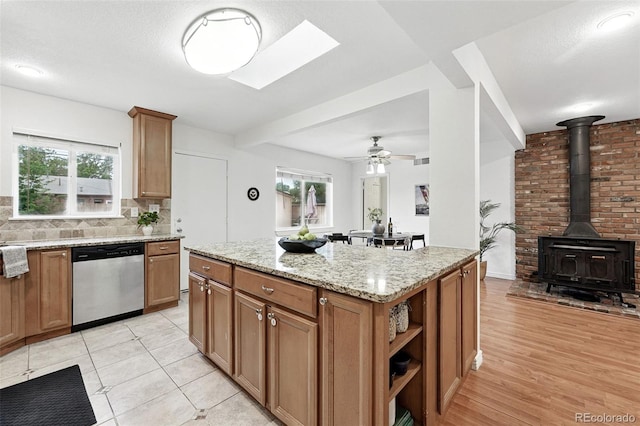 981 Ursula St, Aurora, CO 80011 - kitchen featuring dishwasher, light stone countertops, plenty of natural light, and decorative backsplash