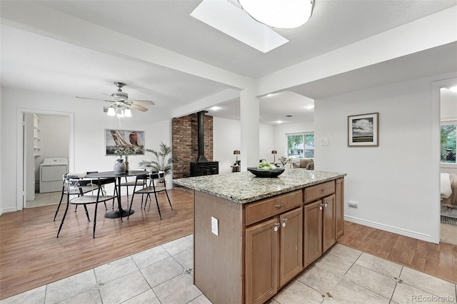 981 Ursula St, Aurora, CO 80011 - kitchen with a wood stove, washer / dryer, light tile patterned flooring, light stone countertops, and recessed lighting