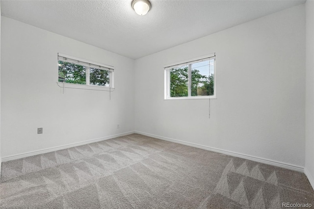 981 Ursula St, Aurora, CO 80011 - carpeted spare room with plenty of natural light, baseboards, and a textured ceiling