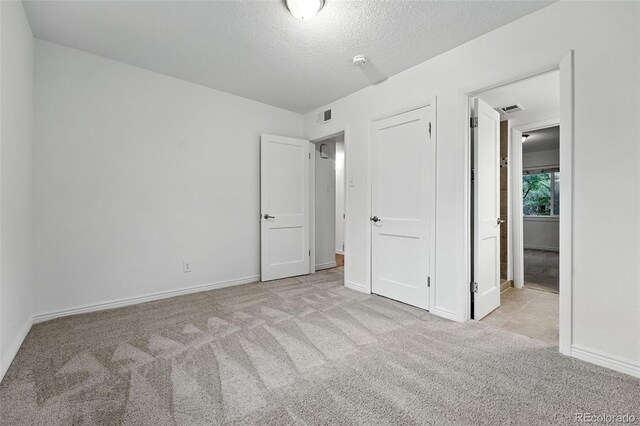 981 Ursula St, Aurora, CO 80011 - unfurnished bedroom featuring carpet floors, a textured ceiling, and baseboards