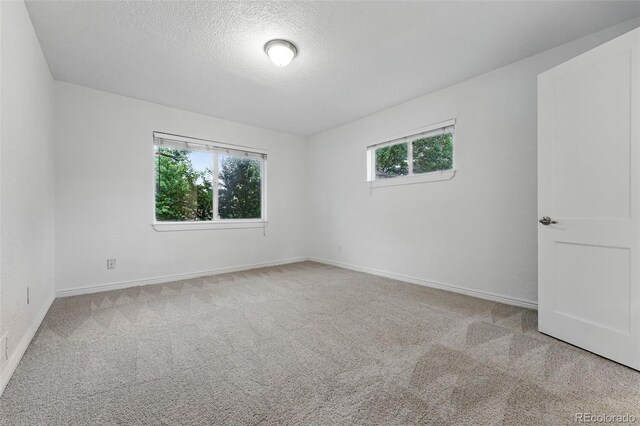 981 Ursula St, Aurora, CO 80011 - carpeted spare room with a textured ceiling and baseboards