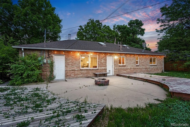 981 Ursula St, Aurora, CO 80011 - back of house at dusk with a patio and brick siding