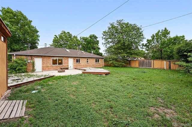 981 Ursula St, Aurora, CO 80011 - back of property with a patio area, a wooden deck, and brick siding