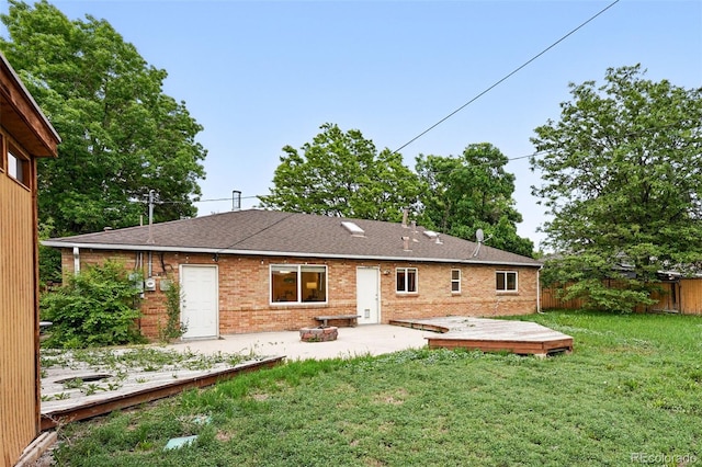 981 Ursula St, Aurora, CO 80011 - rear view of property featuring a deck, brick siding, a patio area, and a shingled roof