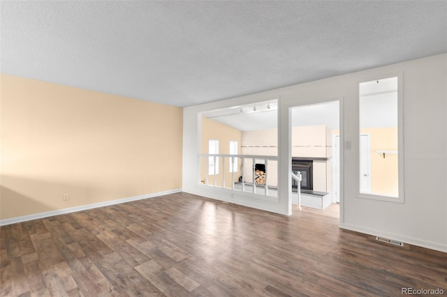 600 Bronco Rd, Denver, CO 80221 - unfurnished living room with dark wood finished floors, a fireplace with raised hearth, and a textured ceiling