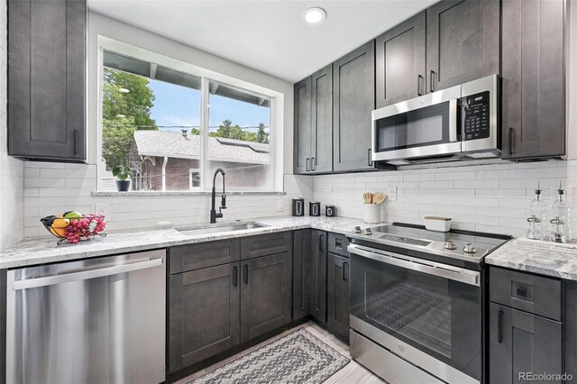 3344 W 33rd Ave, Denver, CO 80211 - kitchen with appliances with stainless steel finishes, a sink, light stone countertops, tasteful backsplash, and recessed lighting