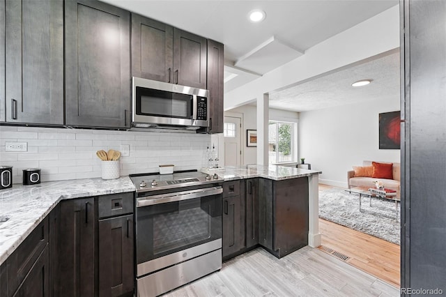 3344 W 33rd Ave, Denver, CO 80211 - kitchen featuring appliances with stainless steel finishes, decorative backsplash, light wood-type flooring, light stone counters, and recessed lighting