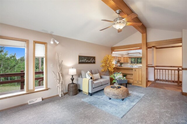 unfurnished living room featuring vaulted ceiling with beams, ceiling fan, visible vents, baseboards, and carpet