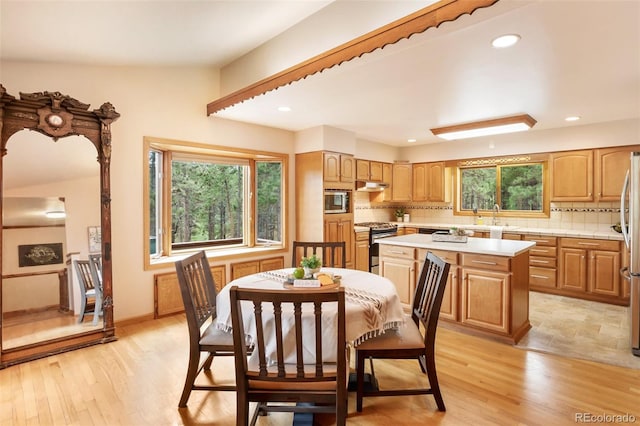 dining room featuring light wood-type flooring, a healthy amount of sunlight, and recessed lighting