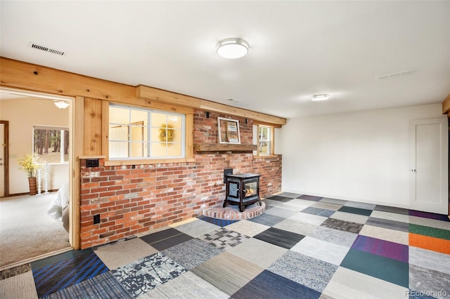 interior space featuring visible vents, carpet flooring, and a wood stove