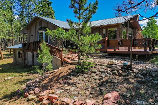 exterior space featuring metal roof, board and batten siding, and a wooden deck