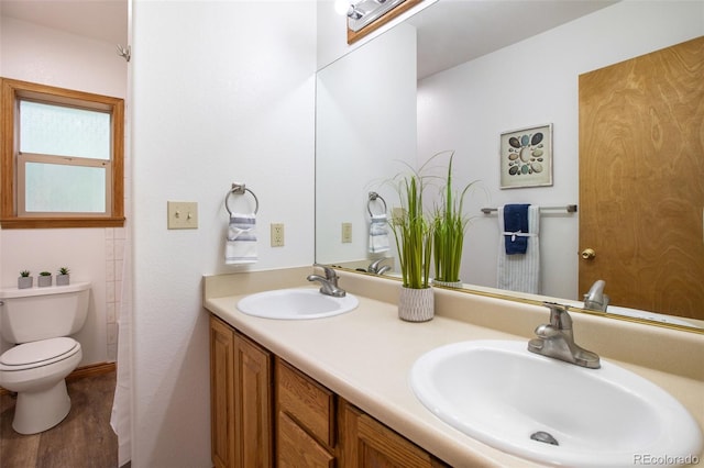 bathroom featuring wood-type flooring, vanity, and toilet