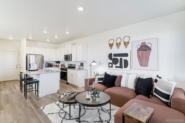 living area with light wood-type flooring and recessed lighting