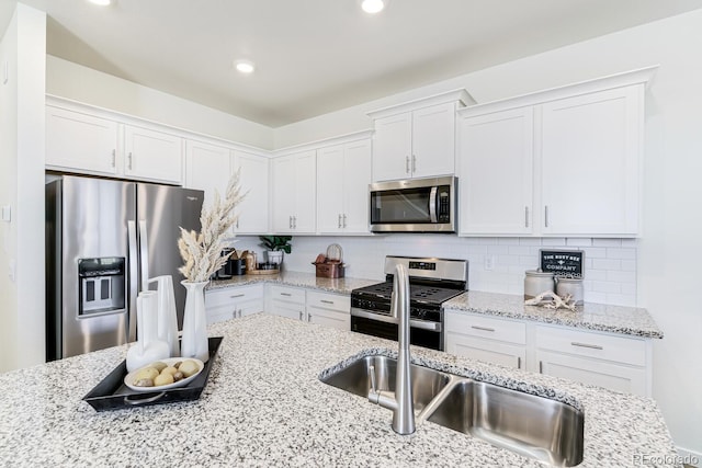 kitchen featuring appliances with stainless steel finishes, white cabinetry, and tasteful backsplash