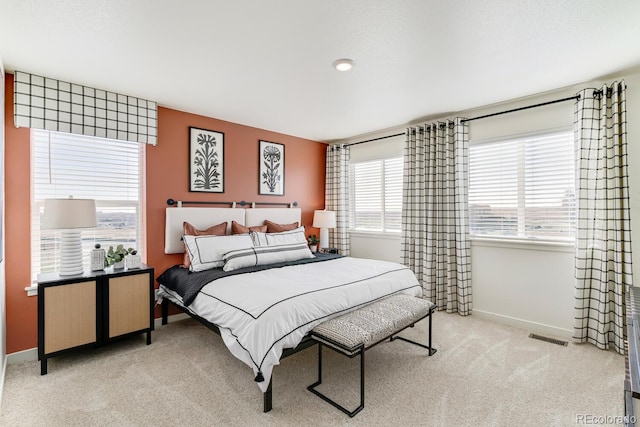 bedroom featuring baseboards, visible vents, and light colored carpet