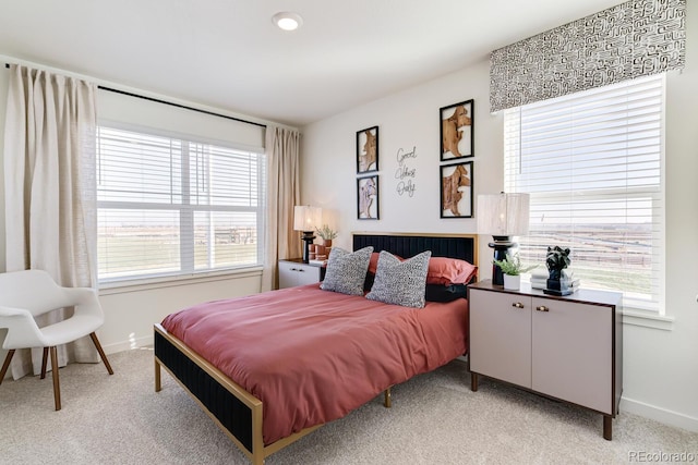 bedroom with light carpet and baseboards