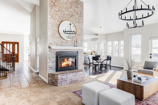 tiled living room with a chandelier, lofted ceiling, and a brick fireplace