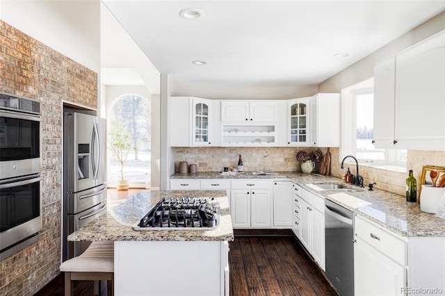 kitchen with white cabinets, sink, dark hardwood / wood-style floors, light stone countertops, and appliances with stainless steel finishes