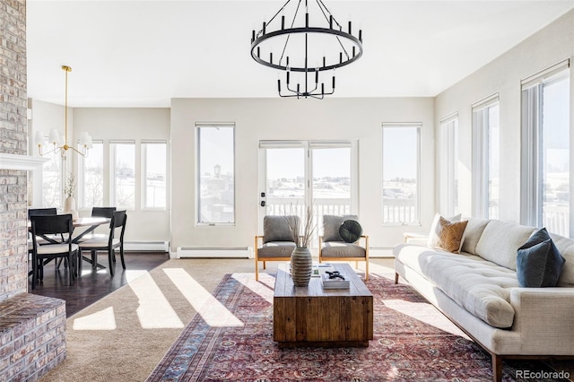 living room with a baseboard heating unit, a wealth of natural light, and a notable chandelier