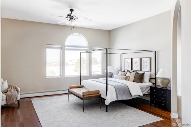 bedroom with dark hardwood / wood-style flooring, a baseboard radiator, and ceiling fan