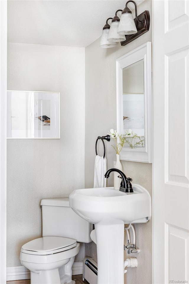 bathroom with a baseboard radiator and toilet