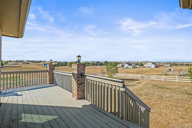 wooden deck with a yard and a rural view