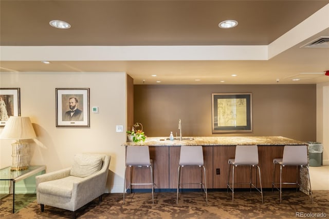 bar with recessed lighting, visible vents, a sink, and baseboards