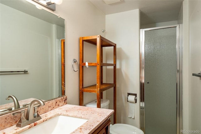 bathroom with a shower stall, toilet, and vanity