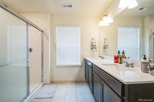 bathroom featuring walk in shower, vanity, tile patterned floors, and a wealth of natural light